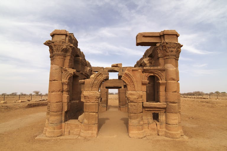 Explore the magnificent ancient ruins of Naqa, captured under a bright blue sky in a vast desert.